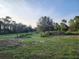Expansive grassy land with scattered trees on a sunny day at 600 Lake Butler Ave, Osteen, FL 32764