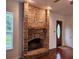 Inviting living room featuring a brick fireplace, hardwood floors, and a classic entryway at 600 Lake Butler Ave, Osteen, FL 32764