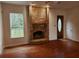 Cozy living room with a brick fireplace, hardwood floors, and a bright window at 600 Lake Butler Ave, Osteen, FL 32764