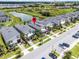Enjoy this aerial view of the townhome community with a pond and beautiful landscaping at 661 Drop Shot Dr, Davenport, FL 33896
