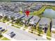 Enjoy this aerial view of the townhome community with a pond and beautiful landscaping at 661 Drop Shot Dr, Davenport, FL 33896