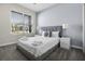 Comfortable bedroom with a queen bed, stylish linens, and a large window with views of the community at 661 Drop Shot Dr, Davenport, FL 33896