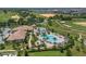 Aerial view of community pool area with palm trees, lounge chairs, and a well-maintained golf course at 661 Drop Shot Dr, Davenport, FL 33896