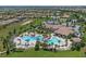 Community pool with palm trees, lush landscaping, lounge chairs, and dining areas offering a resort-style atmosphere at 661 Drop Shot Dr, Davenport, FL 33896