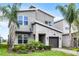 A charming two-story house with a modern design, beautiful stonework, and lovely landscaping at 661 Drop Shot Dr, Davenport, FL 33896