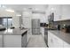 Modern kitchen with stainless steel appliances, a large island, and stylish white cabinets and backsplash at 661 Drop Shot Dr, Davenport, FL 33896