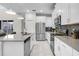 Modern kitchen with stainless steel appliances, a large island, and stylish white cabinets and backsplash at 661 Drop Shot Dr, Davenport, FL 33896