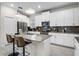 A modern kitchen featuring white cabinets, stainless steel appliances, and a gray tiled backsplash at 661 Drop Shot Dr, Davenport, FL 33896
