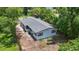 Aerial view of a home with a gray shingle roof surrounded by mature trees, with a ladder propped on the side at 722 Carlson Dr, Orlando, FL 32804