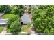 Aerial view of a home with a gray shingle roof surrounded by mature trees on a sunny day at 722 Carlson Dr, Orlando, FL 32804