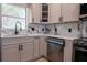 Modern kitchen with stainless steel dishwasher, range and white marble countertops and backsplash at 722 Carlson Dr, Orlando, FL 32804