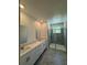 Bathroom featuring double vanity sinks and a walk-in glass shower at 7717 Stone Creek Trl, Kissimmee, FL 34747