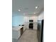 Well-lit kitchen featuring new stainless steel appliances and a gray tile floor at 7717 Stone Creek Trl, Kissimmee, FL 34747