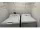 Practical laundry room featuring a white washer and dryer set with overhead shelving at 775 Longboat Dr, Davenport, FL 33896