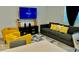 Stylish living room featuring a gray sofa, yellow armchairs, and a TV at 775 Longboat Dr, Davenport, FL 33896