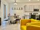 Open living space with kitchen, dining area, and yellow armchairs at 775 Longboat Dr, Davenport, FL 33896
