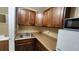 Well-lit kitchenette with wood cabinets, sink, countertop, and refrigerator with microwave on top at 7900 S Orange Blossom Trl # 2074, Orlando, FL 32809