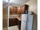 Functional kitchenette with wood cabinets, sink, countertop, and refrigerator with microwave at 7900 S Orange Blossom Trl # 2074, Orlando, FL 32809