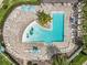 An aerial view of the community pool with lounge chairs and umbrellas on a brick patio at 9071 Woodland Forest Rd, Orlando, FL 32836