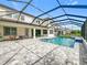 A screened backyard pool with patio furniture in a well maintained yard and home at 9071 Woodland Forest Rd, Orlando, FL 32836