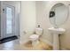 Bathroom with tile flooring, pedestal sink, toilet, shower, and a door leading to the exterior at 9071 Woodland Forest Rd, Orlando, FL 32836
