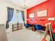 Bright bedroom with a red accent wall, carpet flooring, and a decorative chandelier light at 9071 Woodland Forest Rd, Orlando, FL 32836