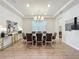 Formal dining room with chandelier lighting, tray ceiling, hardwood floors and seating for ten at 9071 Woodland Forest Rd, Orlando, FL 32836