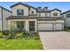 Charming two-story home with lush landscaping, a tile roof, and a three-car garage at 9071 Woodland Forest Rd, Orlando, FL 32836