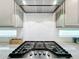Close up of the stainless steel gas range cooktop and white subway tile in the modern kitchen at 9071 Woodland Forest Rd, Orlando, FL 32836