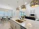 Modern kitchen island with sink overlooking the living room and breakfast nook with seating at 9071 Woodland Forest Rd, Orlando, FL 32836
