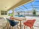 Outdoor patio and dining area with view of the backyard pool and greenery at 9071 Woodland Forest Rd, Orlando, FL 32836