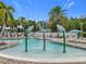 Community splash pad with palm tree water feature and ample seating, providing a fun and refreshing experience at 9071 Woodland Forest Rd, Orlando, FL 32836