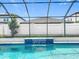 A screened pool featuring a waterfall with a view of the backyard fence on a clear day at 9071 Woodland Forest Rd, Orlando, FL 32836