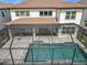 A screened-in pool area with a beautiful tile surround and outdoor dining space at 9071 Woodland Forest Rd, Orlando, FL 32836