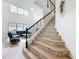 Elegant staircase with decorative iron railing and mosaic tile risers, hardwood floors, and living area at 9071 Woodland Forest Rd, Orlando, FL 32836