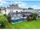 Aerial view of a home with a screened pool and lush landscaping showcases the perfect backyard retreat at 909 Troon Cir, Davenport, FL 33897