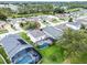 An aerial view displays home's backyard pool, surrounded by green lawn, and neighborhood at 909 Troon Cir, Davenport, FL 33897