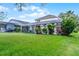 Picturesque backyard featuring a screened pool, lush landscaping, and a well-manicured lawn for outdoor enjoyment at 909 Troon Cir, Davenport, FL 33897