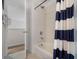 Well-maintained bathroom with a shower/tub combo and nautical-themed shower curtain at 909 Troon Cir, Davenport, FL 33897