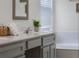 Bathroom with painted vanity, white countertop, faucet, and decorative green plant at 909 Troon Cir, Davenport, FL 33897
