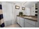 Bright bathroom with a large mirror, neutral walls, and white vanity at 909 Troon Cir, Davenport, FL 33897