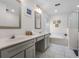 Well-lit bathroom boasts double sinks, soaking tub, and glass shower at 909 Troon Cir, Davenport, FL 33897