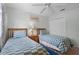 Cozy bedroom featuring two twin beds with blue checkered bedding and a ceiling fan at 909 Troon Cir, Davenport, FL 33897