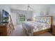 Primary bedroom with ceiling fan, king bed, and a window overlooking the pool at 909 Troon Cir, Davenport, FL 33897