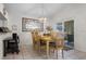 Dining area with a wooden table, six chairs, decorative mirror, and sliding glass door access at 909 Troon Cir, Davenport, FL 33897