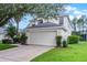 Two-story home with attached garage, well-manicured lawn, and mature landscaping at 909 Troon Cir, Davenport, FL 33897