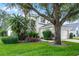 Beautiful home exterior showcasing lush landscaping, mature trees, and well-maintained lawn at 909 Troon Cir, Davenport, FL 33897