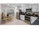 Bright kitchen and breakfast nook with stainless steel appliances and modern white cabinets at 909 Troon Cir, Davenport, FL 33897