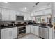 Modern kitchen with white cabinets, stainless steel appliances, and a view into the dining area at 909 Troon Cir, Davenport, FL 33897