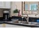 Close-up of a kitchen sink with stainless steel faucet, modern appliances, and granite countertops at 909 Troon Cir, Davenport, FL 33897